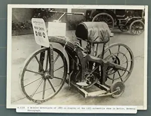 Prints of (Original Caption). Evolution of the motorcycle...A Daimler motorcycle of 1885 on display at the 1925 Automobile Show in Berlin, Germany, clearly showing the progress which has been made in this field Vintage Car Collection Prints: Daimler Motorcycle