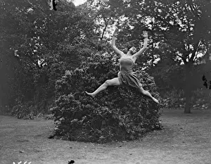 Dancing Dryad, a tunic clad Margaret Morris dancer leaping barefoot over the grass