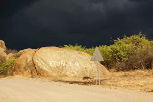 Dark storm front over rocks with signpost Epupa 36 km, Kaokoland, Kunene, Namibia