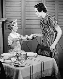 Household Prints: Daughter (8-9) helping mother setting table for breakfast (B&W)