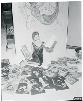 Debra Paget Reviewing a Batch of Photographs