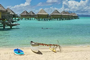 Images Dated 14th March 2013: Decorated outrigger boat in front of overwater bungalows, Bora Bora, French Polynesia