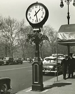 Incidental People Collection: Decorative street clock, two background people standing on street, (B&W)