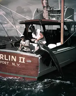 Pulling Prints: Deep Sea Fishing Boat Man At Helm Two Men On Stern One Hold Rod Reel One Pulls Fish