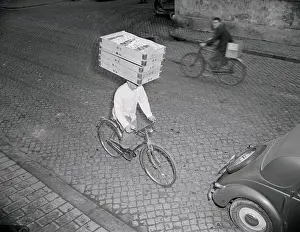 Delivery Boy Riding Bicycle with Box on Head