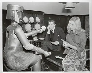 Denis Hamilton Playing Cards with His Wife and a Robot