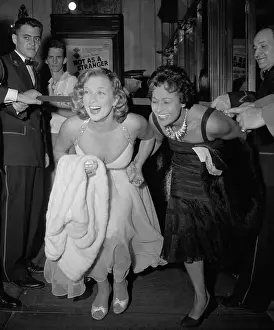 Denise and Helene Darcel Bending Under Ribbon