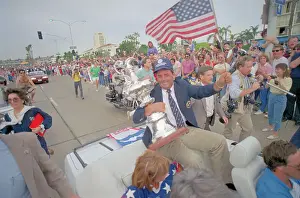Dennis Conner Holding Trophy and Waving Flag