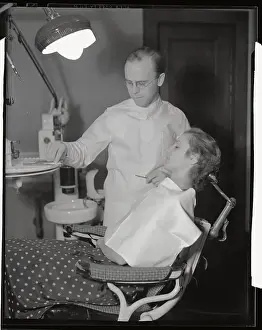 Dentist Preparing to Treat Female Patient