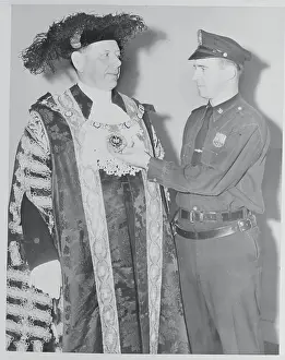 Denys Lowson Wearing Elaborate Robe Talks With Policeman