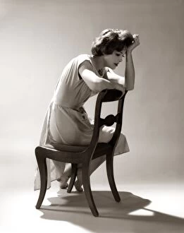 Retrofile Gallery: Depressed Sad Moody Woman Leaning Head Onto Arm Slouched Lean Back Of Chair Seated Depression Stress