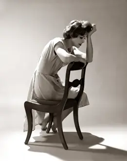 Depressed Sad Moody Woman Leaning Head Onto Arm Slouched Lean Back Of Chair Seated Depression Stress