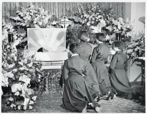 Grief Prints: Dionne Sisters Kneeling in Front of Casket