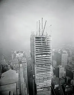 Prints of (Original Caption). The flag flies from the final steel column of the 60 story Chase Manhattan Bank Building rising on site bounded by Nassau, Liberty, William and Pine Streets Daredevil Construction Worker Prints: Distant View of Workers Atop Skyscraper