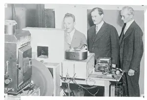 Prints of NEW YORK: (L TO R)THE ANNOUNCER, DR. E.F.W. ALEXANDERSON, INVENTOR, AND DR. MCFARLAN MOORE OF G.E. WATCHING A DEMONSTRATION OF ALEXANDERSON'S RADIO TELEVISION DEVICE WHICH TRANSMITS IMAGES BY RADIO Front Page: Framing History as it Happens: Dr. Alexanderson and Associates Watching Demonstration