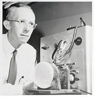 Dr. Edwin Muller Examining Microscope Display