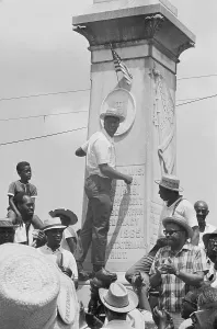 Grenada Prints: Dr. Green Plants US Flag On War Monument