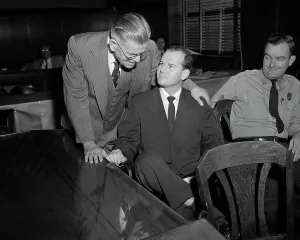 Suspect Prints: Dr. Samuel Sheppard Smiles at His Father During Trial