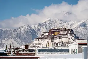 China Prints: Dramatic view of the Potala Palace rising above the roofs of Lhasa in Tibet