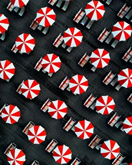 Drone image directly above beach umbrellas, Massa, Italy