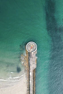 A fascinating collection of images featuring great British piers: Drone shot above a small lighthouse on a pier, Looe, Cornwall, United Kingdom