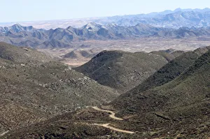 Dry valley with road in a Karoo landscape at Helskloof Pass, Richtersveld National Park, Namaqualand Dry valley with road in a Karoo landscape at Helskloof Pass, Richtersveld National Park, Namaqualand