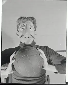 Prints of (Original Caption). The player shown is dressed in a costume worn by players in the early 1990s Hoops Through Time: A Visual Journey of Basketball History: Early Player Wearing Mask with Basketball