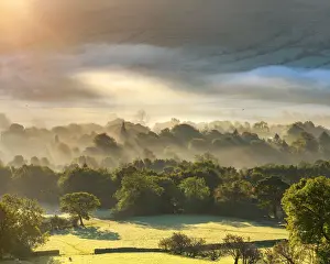 Edale village sunrise with mist and fog and golden light at sunrise. English Peak District. UK