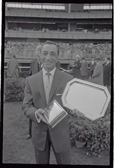 Eddie Arcaro Holding Silver Trophies