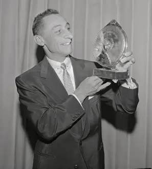 Eddie Arcaro Looking at Reflection in Trophy