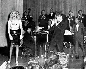 Prints of American comedienne, actress, singer and businesswoman Edie Adams (1927-2008), dressed up as Jayne Mansfield, laughs as she stands on stage with an Ed Sullivan lookalike in Philadelphia Hollywood's Blonde Bombshell in Focus: Edie Adams As Jayne Mansfield