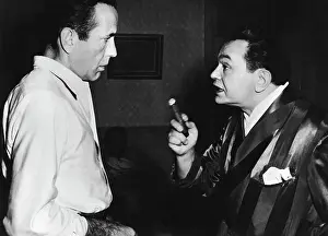 Prints of Actor Edward G. Robinson with cigar is speaking to actor Humphrey Bogart. Undated photograph The Essence of Cool: Edward G. Robinson Speaking to Humphrey Bogart