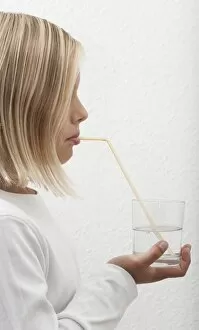 Nourishment Collection: Eight-year-old girl drinking mineral water through a straw