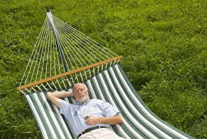 Satisfaction Gallery: Elderly gentleman lying in a hammock and listening to music