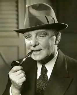 Elderly man in fedora smoking pipe