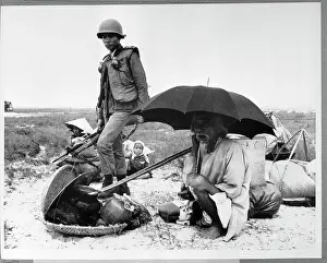 Elderly Vietnamese Man Sits Under Umbrella