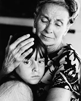 Candidate Terms Prints: Elderly woman embracing and comforting forlorn-looking granddaughter