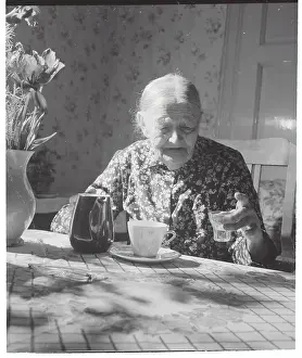 Elderly Woman at Table with Schnapps Liquor