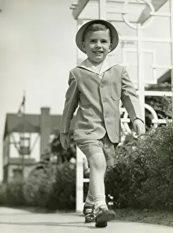 Elegant boy walking on promenade, (B&W)