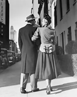 Sidewalk Prints: Elegant couple walking on street, (Rear view) (B&W)