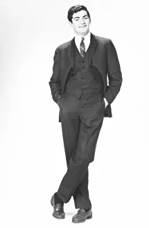 Businessman Prints: Elegant man with hands in pockets posing in studio, (B&W), portrait
