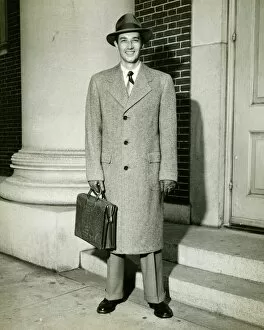 Elegant man posing at entrance to building, (B&W), (Portrait)