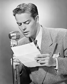 30 35 Years Prints: Elegant man talking into microphone in studio, (B&W)