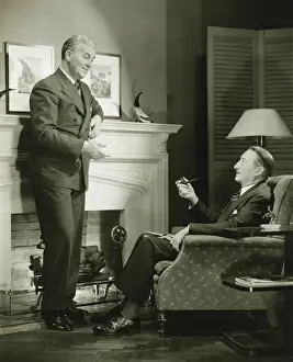 50 59 Years Prints: Two elegant men talking by fireplace, (B&W)