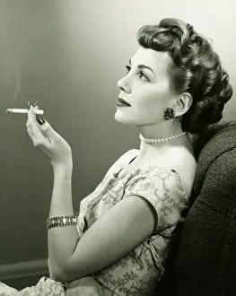 Pearls Prints: Elegant woman smoking cigarette, posing in studio, (B&W), portrait