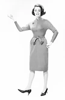 1960s Fashion Gallery: Elegant woman standing in studio, gesturing, (B&W), portrait