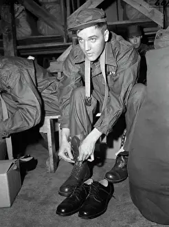 Tying Prints: Elvis Presley in Uniform Tying Shoes