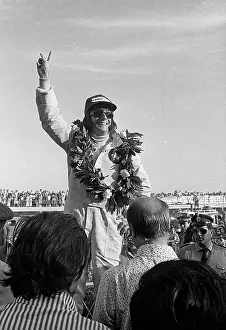 Prints of Brazilian Formula One driver Emerson Fittipaldi, a wreath around his neck, waves from the winner's podium at the Argentine Grand Prix, Buenos Aires, Argentina, January 29, 1973 Legends of the Track: Emerson Fittipaldi On The Podium At The Argentine Grand Prix