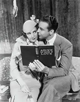 Entertainers Ruby Keeler and Dick Powell Embracing with Book in Hand