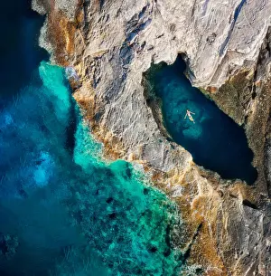 Prints of An early summer morning aerial view of a woman relaxing in the natural sea-water pool called the Dragon's Eye, in the Brbinjscica Bay on the island of Dugi Otok, Croatia Travel Destination Prints: In the Eye of a Dragon
